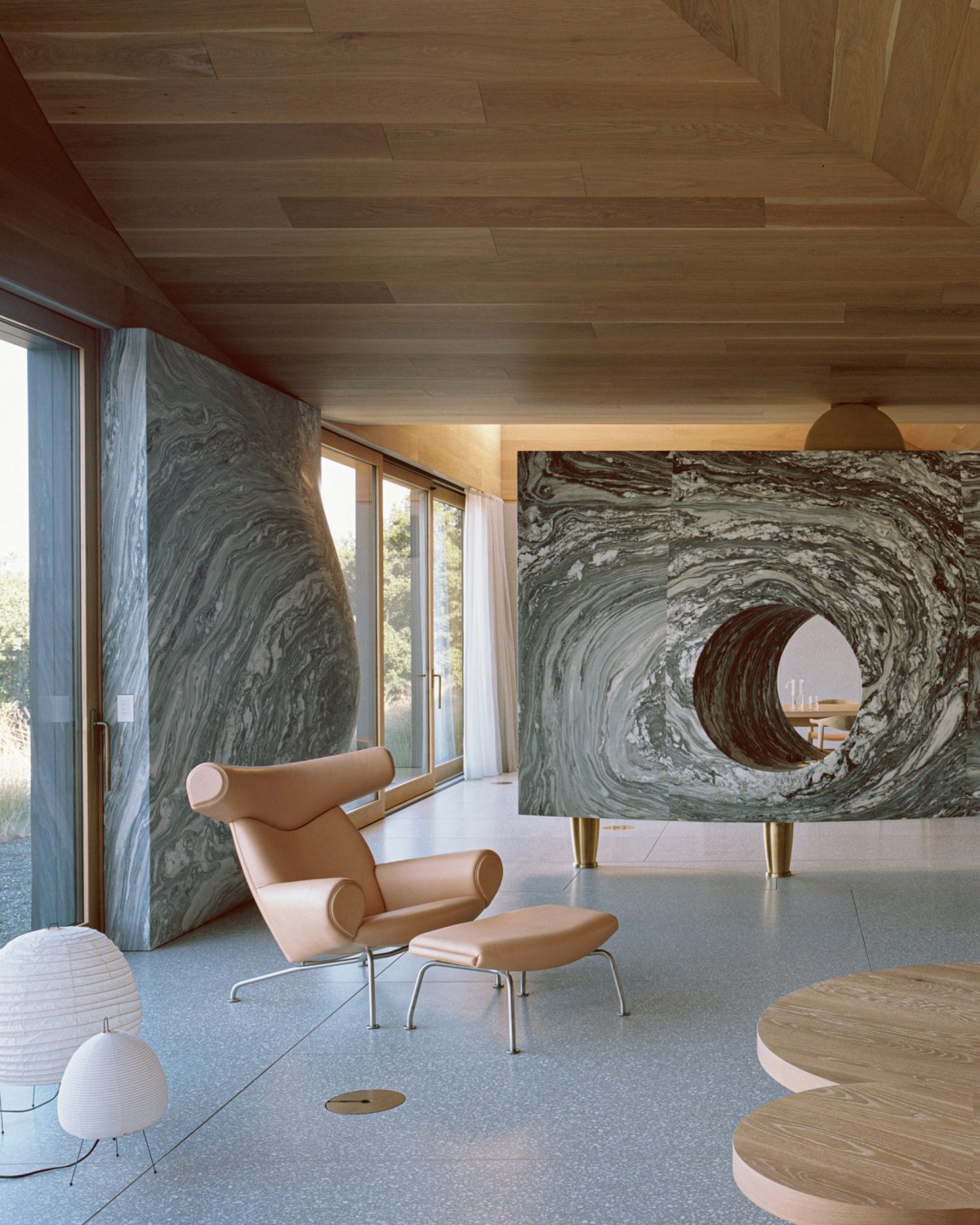 Una chimenea esculpida en mármol Danby separa parcialmente la gran sala de estar diáfana del comedor.