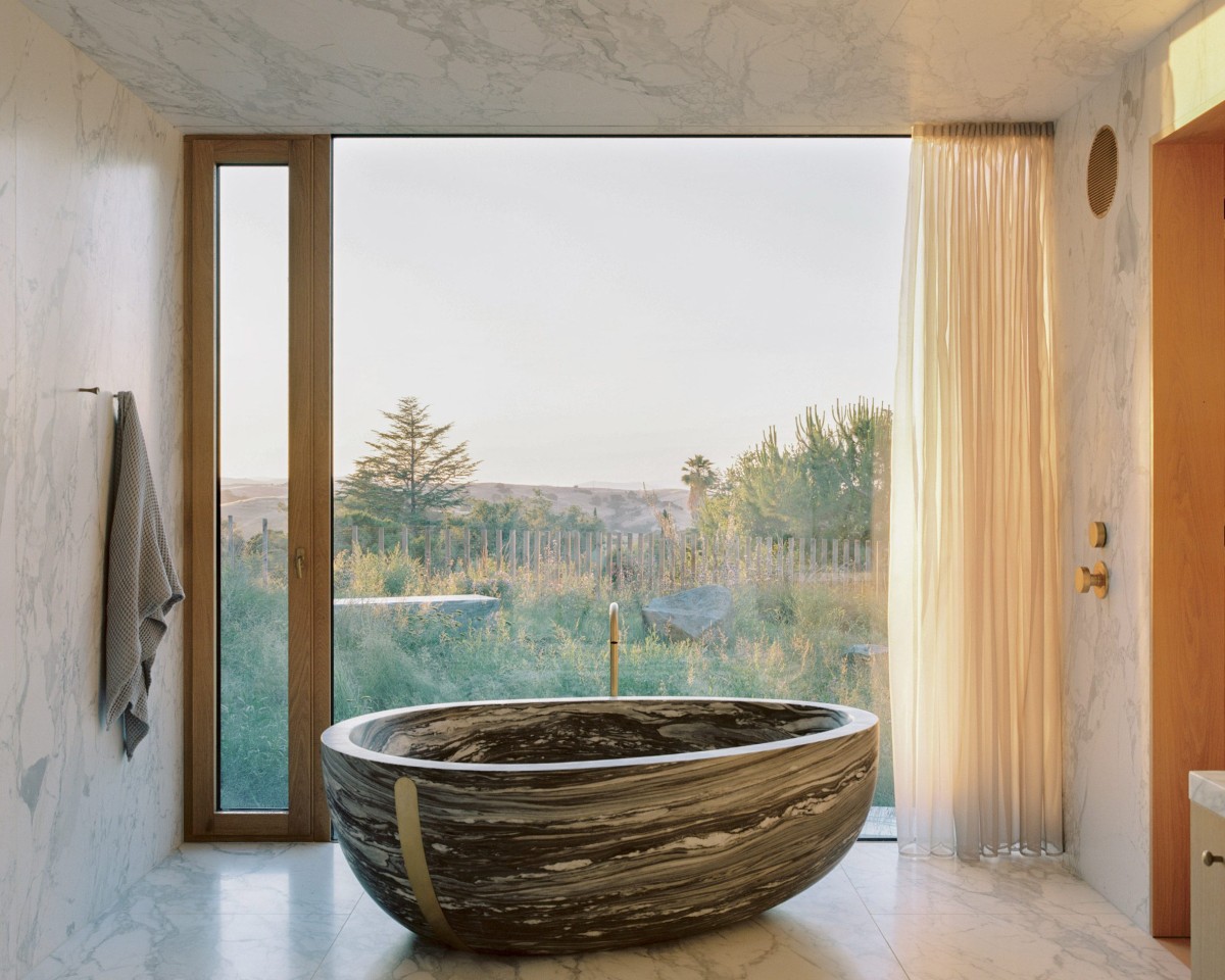 En el baño destaca una bañera ovoide revestida de mármol Danby azul grisáceo.