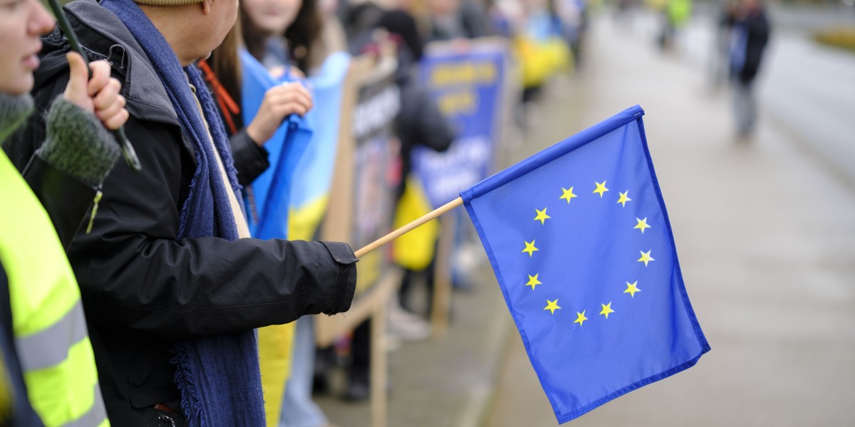 Un hombre sujetando una bandera de la Unión Europea
