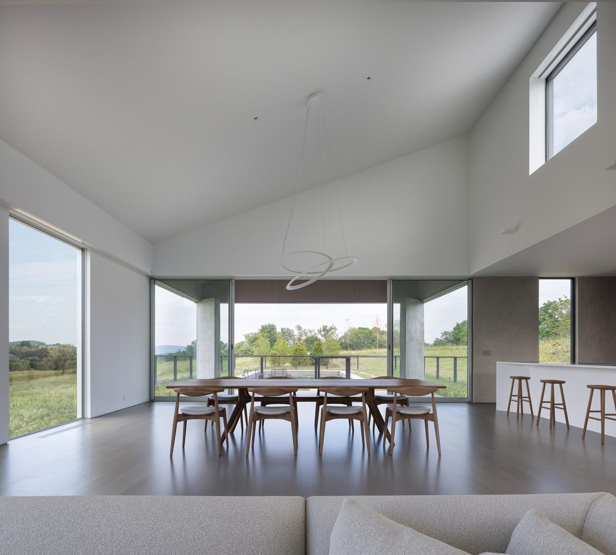 La paleta interior combina madera clara, suelos de hormigón pulido y mobiliario seleccionado para crear un ambiente cálido.