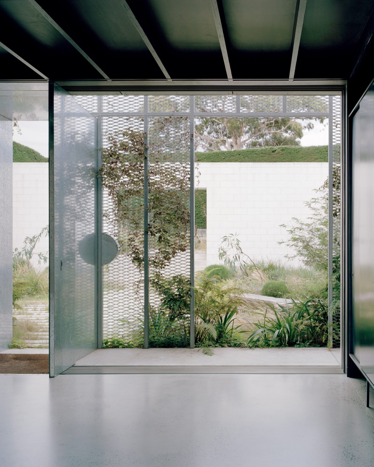 Dos grandes jardines amurallados flanquean la casa y prolongan visualmente la arquitectura hacia el exterior.