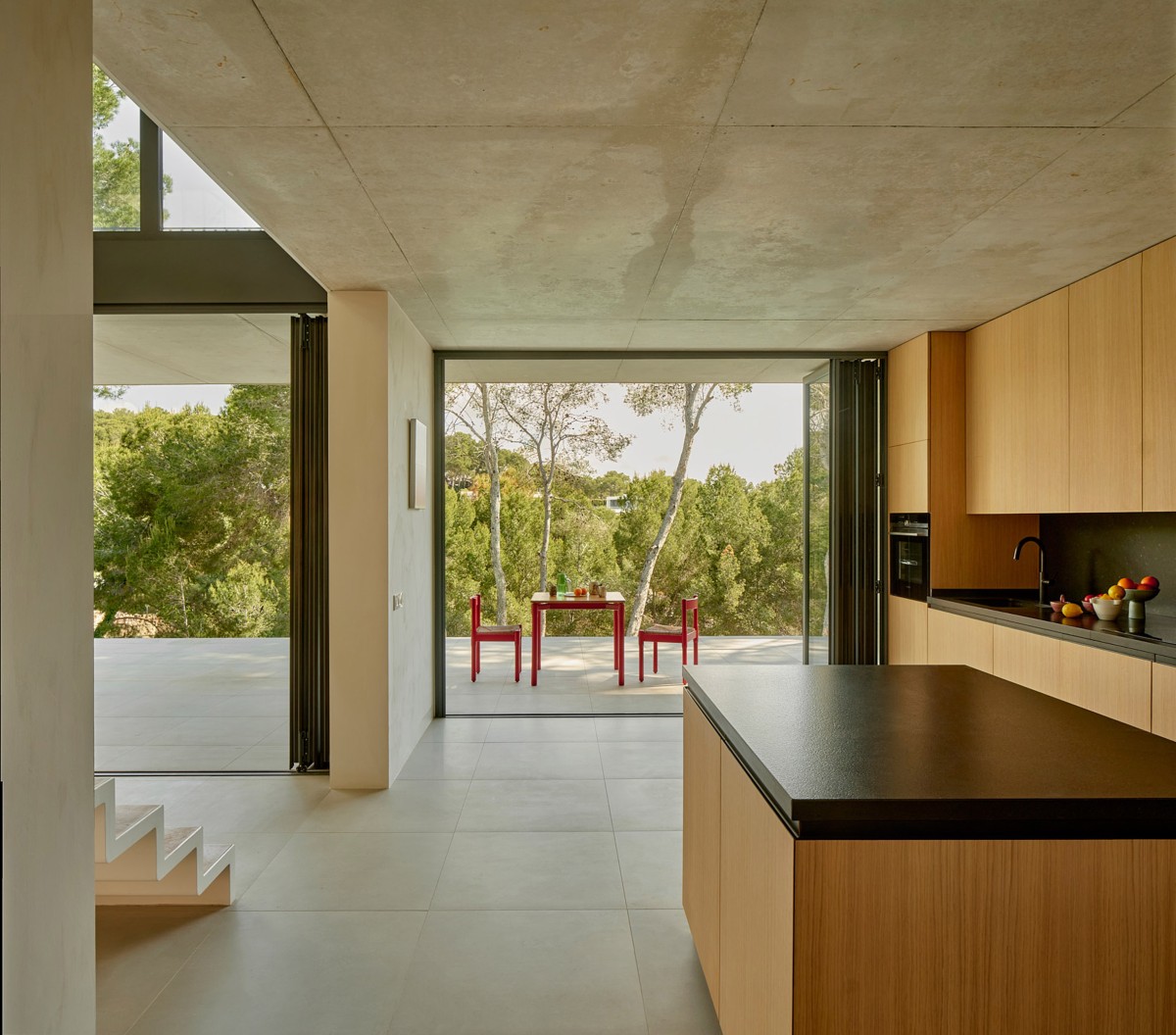 On the opposite side of the sunken courtyard, the living room and kitchen open onto a series of exterior platforms at different levels.
