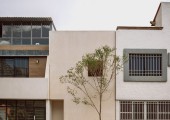 La fachada es plana, revestida con chukum color aren, con una única ventana en sombra y una discreta entrada.