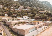Los módulos están revestidos con bloques de granito rugoso que parecen pertenecer al paisaje corso desde siempre.