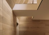 Una cocina discreta y parcialmente iluminada se funde con la sala de estar y da acceso a la escalera de caracol.
