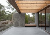 En la terraza, cubierta por una pérgola de madera, el hormigón continúa hacia al exterior.