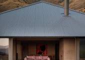 Cuando las puertas correderas están abiertas, la vivienda se convierte en un pabellón permeable donde el viento recorre el interior y las montañas parecen entrar en el salón.