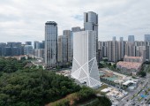 El edificio se erige en un enclave singular, justo en el límite entre el distrito financiero de Xiamen y una colina cubierta de vegetación.