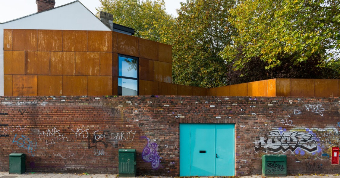 Una peculiar casa revestida con acero que se esconde tras un antiguo muro de ladrillo en Bristol