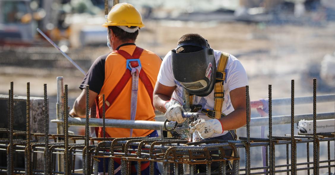 Archivo - Un soldador y un operario trabajando en unas obras