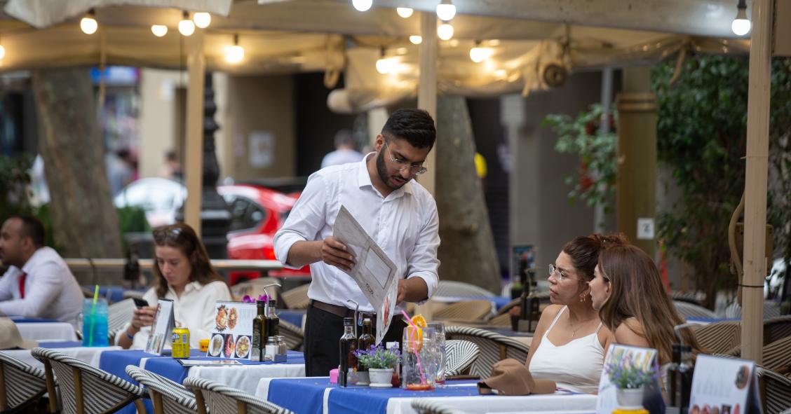 Un camarero atiende a una mesa en las Ramblas