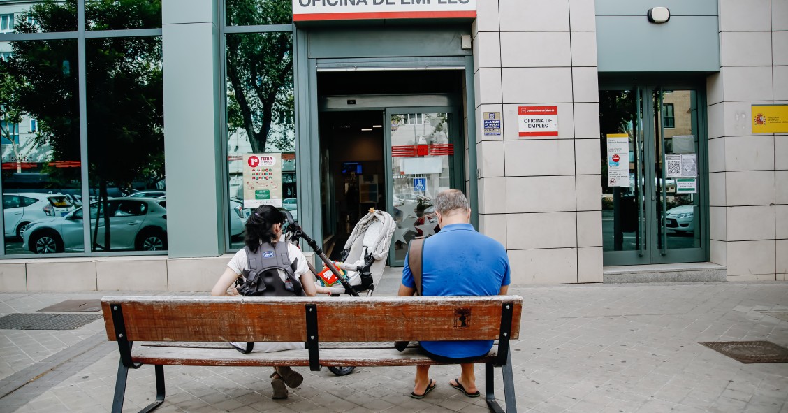 Archivo - Dos personas esperan fuera de una oficina de empleo