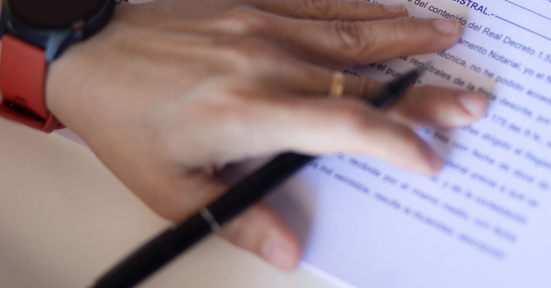 Archivo - Una mujer con un bolígrafo, señala una escritura de compraventa de una hipoteca, a 30 de mayo de 2022, en Madrid (España).