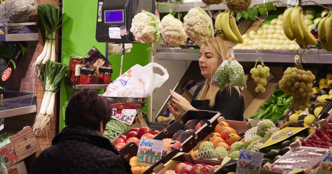 Un dependienta pesa una bolsa con frutas en las compras en los Mercados de Abastos antes de la Navidad , a 23 de diciembre de 2022 en Sevilla (Andalucía, España). 