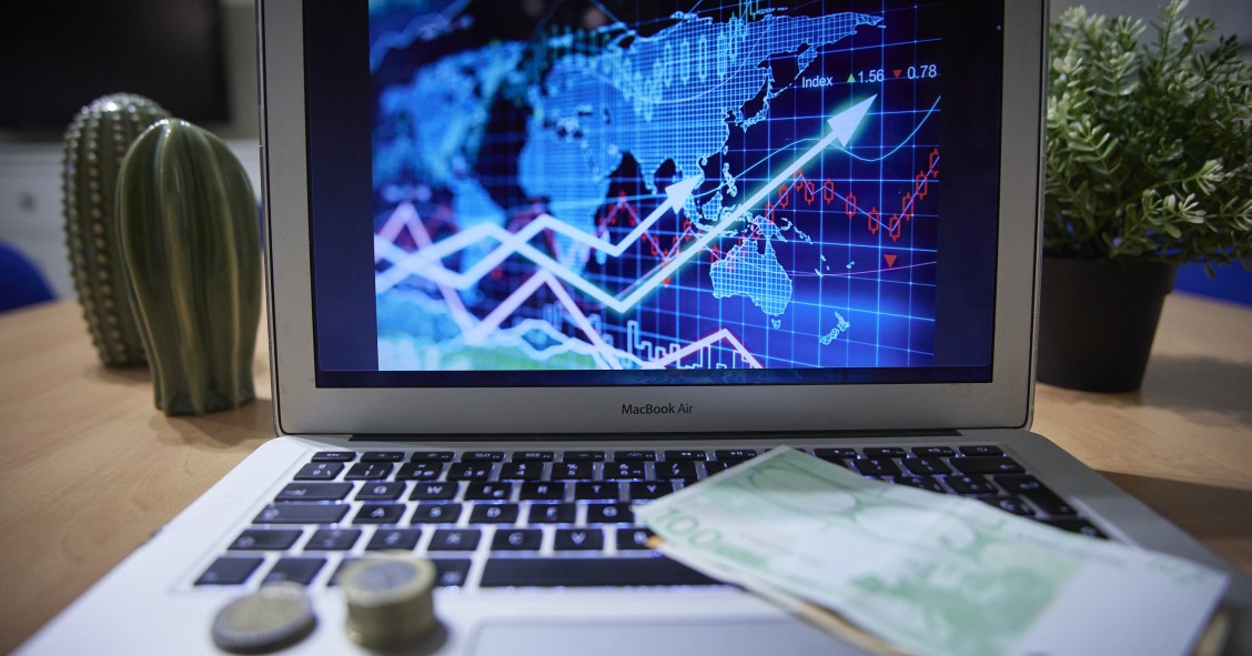 Archivo - Un gráfico en un ordenador portátil con billetes y monedas, a 4 de enero de 2022, en Madrid, (España).