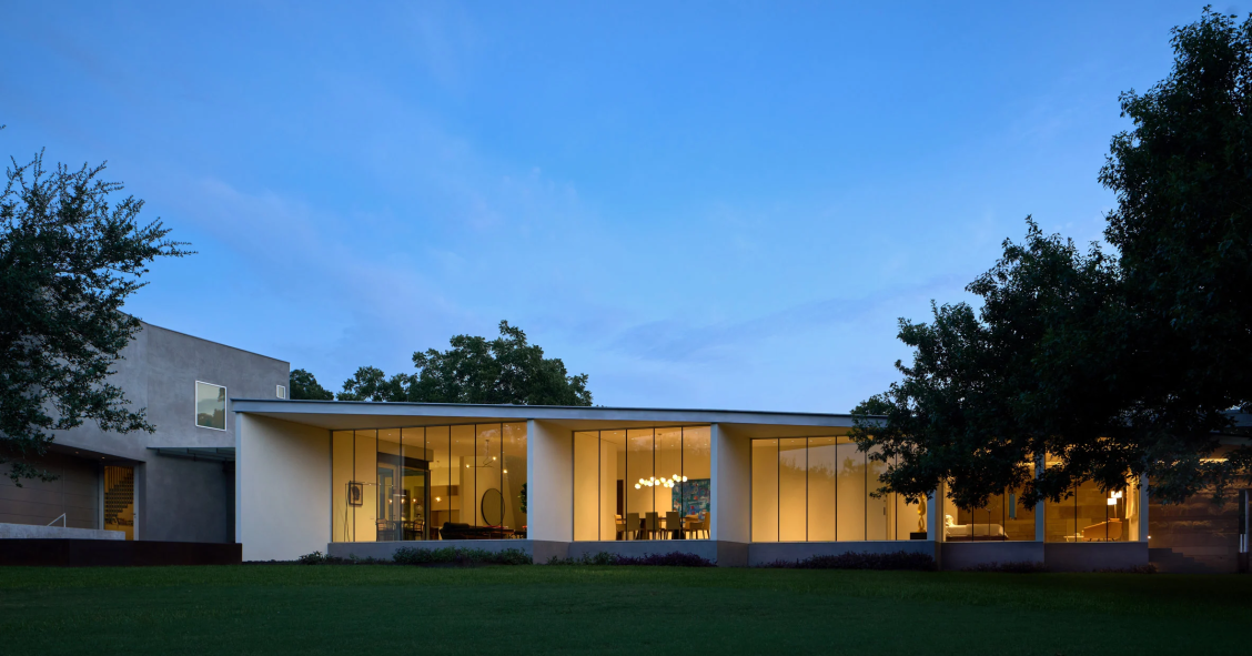 La fachada posterior se abre hacia la reserva boscosa mediante grandes muros-ventana