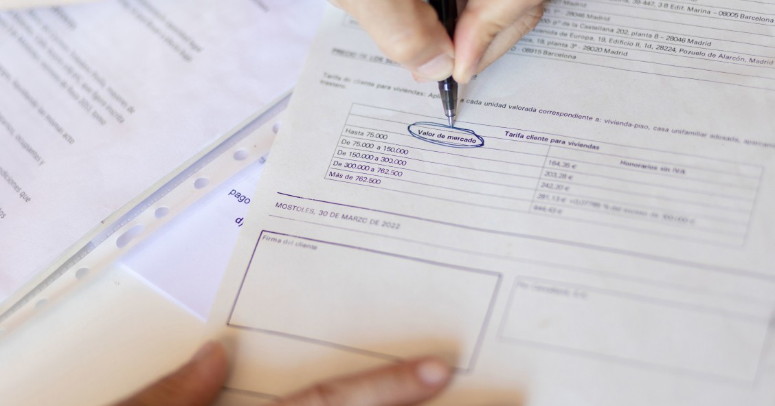 Una mujer señala el valor de mercado de una escritura de compraventa de una hipoteca, a 30 de mayo de 2022, en Madrid (España).