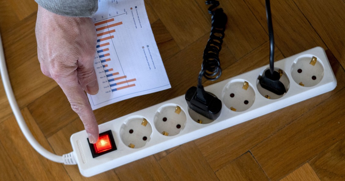 Archivo - Un hombre enciende una largadera con varios enchufes con una factura de luz en la mano, a 3 de enero de 2022, en Madrid, (España). El precio medio de la electricidad en el mercado mayorista vuelve a subir hoy, en concreto un 9,88% con respecto a