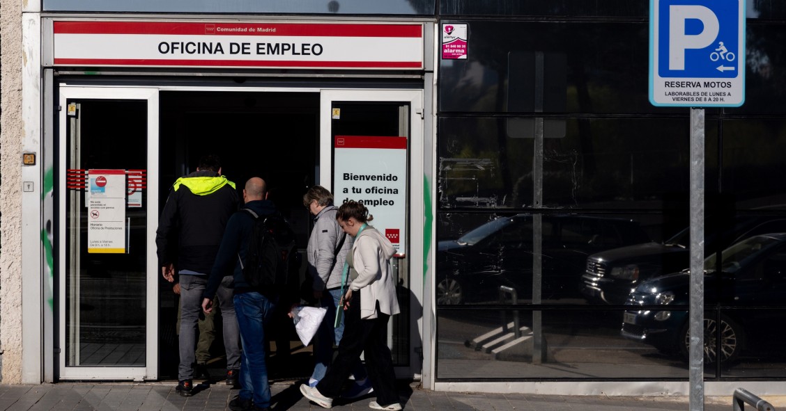 Archivo - Varias personas entrando en una oficina de empleo