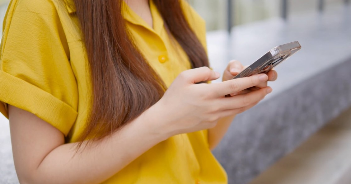 Una mujer consulta su smartphone preocupada por un posible fraude online