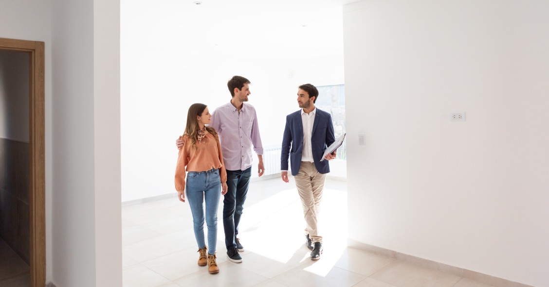 Un agente inmobiliario enseñando una casa a unos posibles compradores