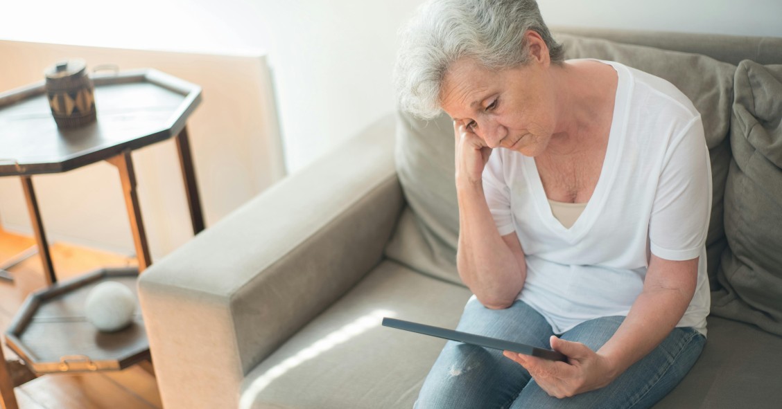 Anciana triste mirando una fotografía