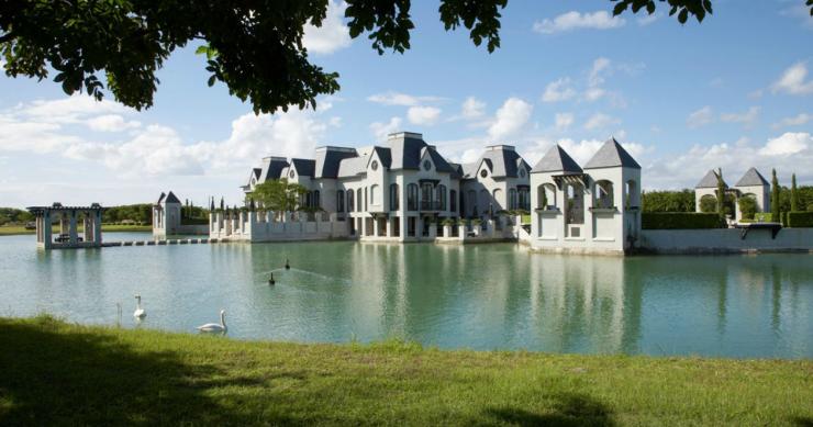 Castillo moderno rodeado de un lago con cisnes