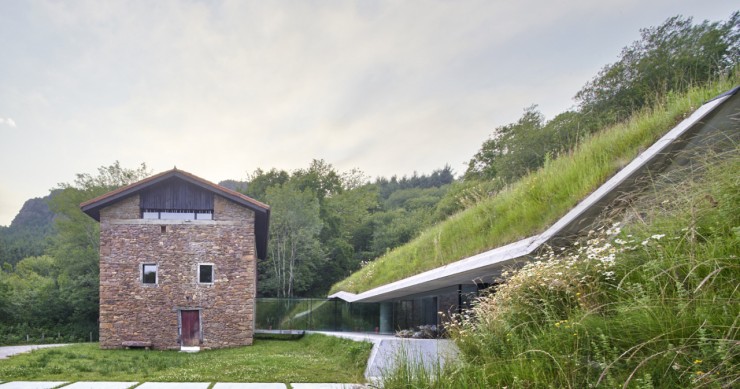 Esta casa tradicional de Navarra esconde una ampliación de diseño escondida bajo la montaña