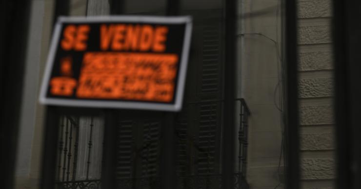 Archivo - Cartel colgado en un edificio que indica que el inmueble está en venta.