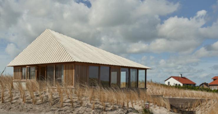 Una casa prefabricada para uso vacacional que emerge de las dunas