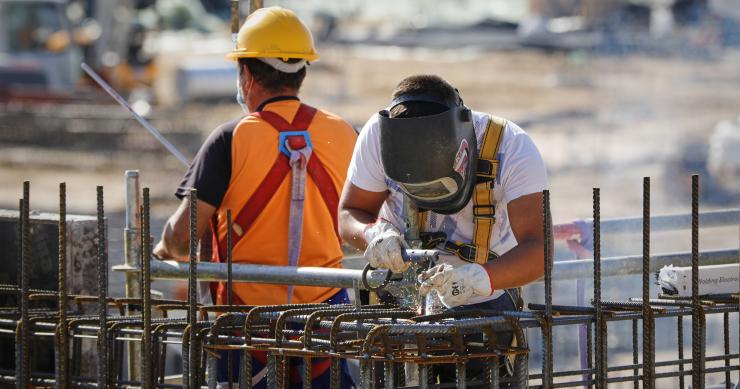 Archivo - Un soldador y un operario trabajando en unas obras
