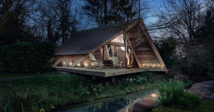 Una cabaña prefabricada de madera desconectada de la red y a orillas de un arroyo