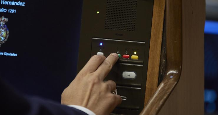 Un miembro del hemiciclo vota en una sesión plenaria, en el Congreso 
