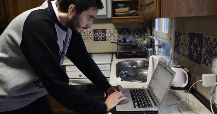 Archivo - Una persona teletrabajando en la cocina de su domicilio