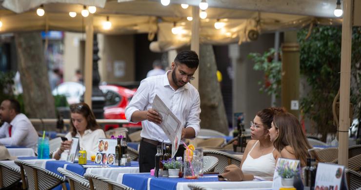 Un camarero atiende a una mesa en las Ramblas
