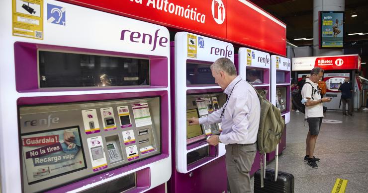 Una persona en una de las máquinas de venta de billetes en la estación Madrid-Atocha Cercanías
