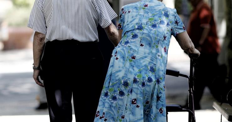 Una pareja de pensionistas paseando por un parque de Madrid