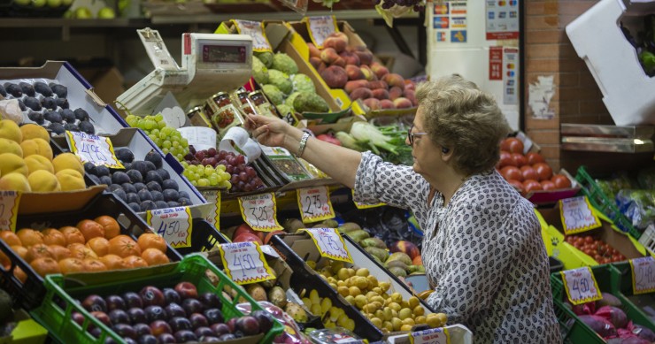 Archivo - Una mujer compra en uno de los puestos del mercado de abastos de Triana. A 13 de septiembre de 2022, en Sevilla (Andalucía, España).