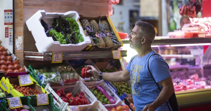 Un hombre comprando en un mercado de abastos de Triana