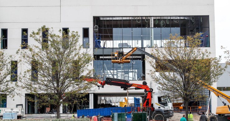 Archivo - Varios obreros trabajan con maquinaria de construcción