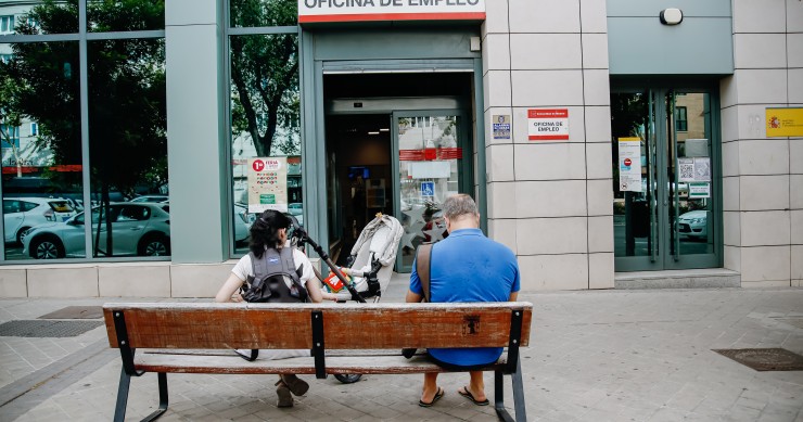 Archivo - Dos personas esperan fuera de una oficina de empleo