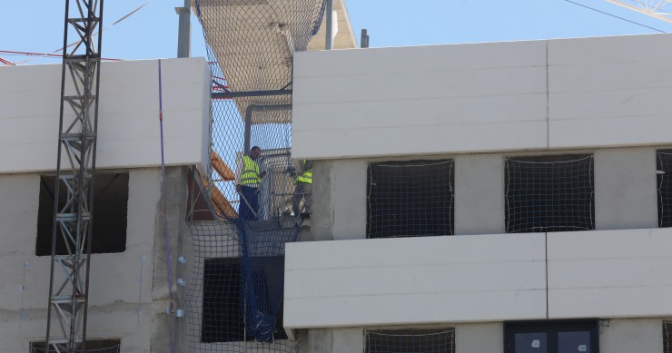 Archivo - Dos obreros trabajando en la construcción de un edificio de viviendas en Madrid