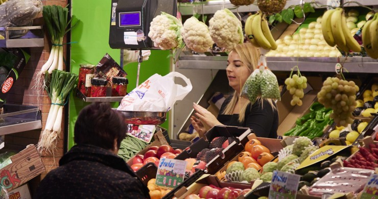 Un dependienta pesa una bolsa con frutas en las compras en los Mercados de Abastos antes de la Navidad , a 23 de diciembre de 2022 en Sevilla (Andalucía, España). 