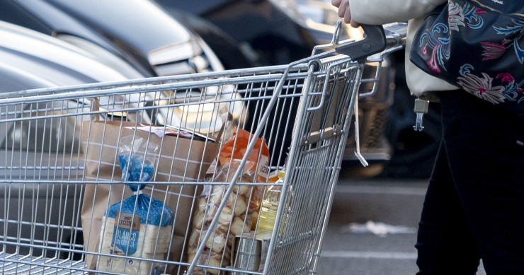 Una mujer sale de un supermercado con un carro de la compra, a 27 de diciembre de 2022, en Mejorada del Campo, Madrid (España). 