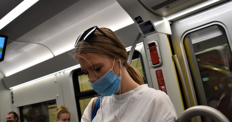 Ragazza con la mascherina in un mezzo pubblico