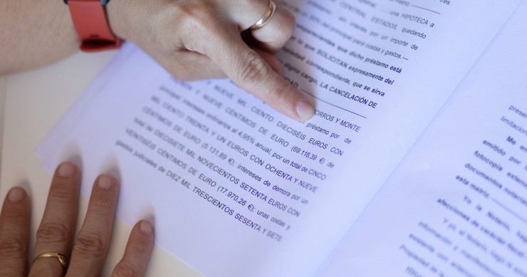 Una mujer señala una escritura de compraventa de una hipoteca, a 30 de mayo de 2022, en Madrid (España). 