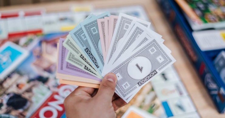 Dinero del Monopoly en la mano