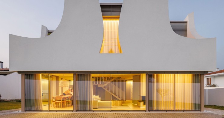 Las curvas de los “pétalos” contrastan con el muro-ventana del piso inferior