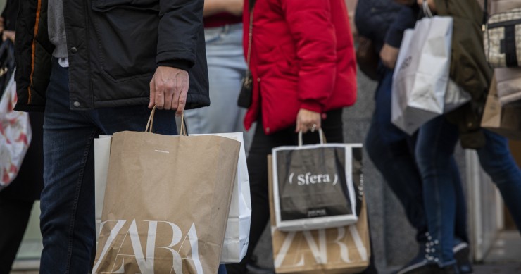 Archivo - Varias personas con bolsas de la compra en una calle centrica. 