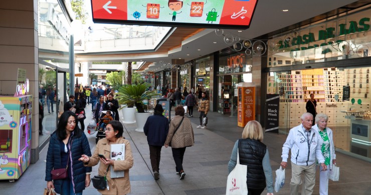 Archivo - Varias personas van de compras en un centro comercial